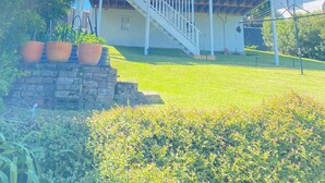 A house with a balcony, a staircase, and a garden. - Dog friendly home with spectacular views of Lake Illawarra (Lake Heights)