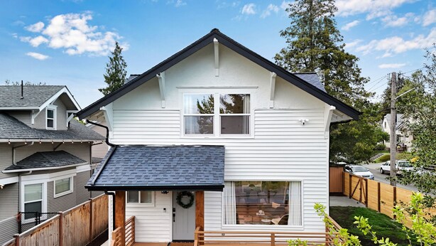 Ein Bungalow mit Veranda, Garage und kleiner Terrasse.