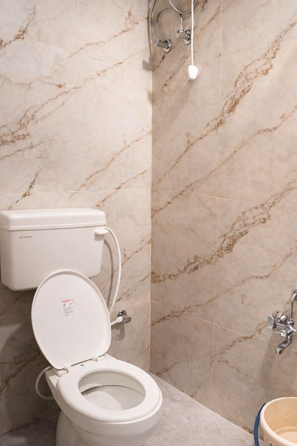 Un bagno con il water, pareti in marmo e un lavandino.