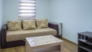 A living room with a sofa, a coffee table, and a bookshelf.