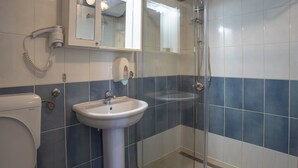 A bathroom with a toilet, sink, and shower.