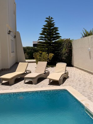 A swimming pool with lounge chairs and a palm tree. - YASSMINE Villa (Djerba Midun)