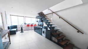 Una cocina moderna con una espiral original, un comedor con sillas rojas y un amplio ventanal que aporta luz natural.