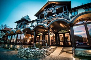 A hotel with a balcony, large windows, and a stone facade. - Hanul Bran (Bran)