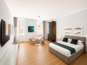 Een moderne hotelkamer met een bed, een bureau, een stoel en een televisie.