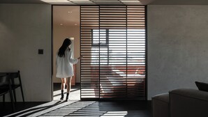 Un intérieur moderne avec une porte coulissante, un canapé et un fauteuil.