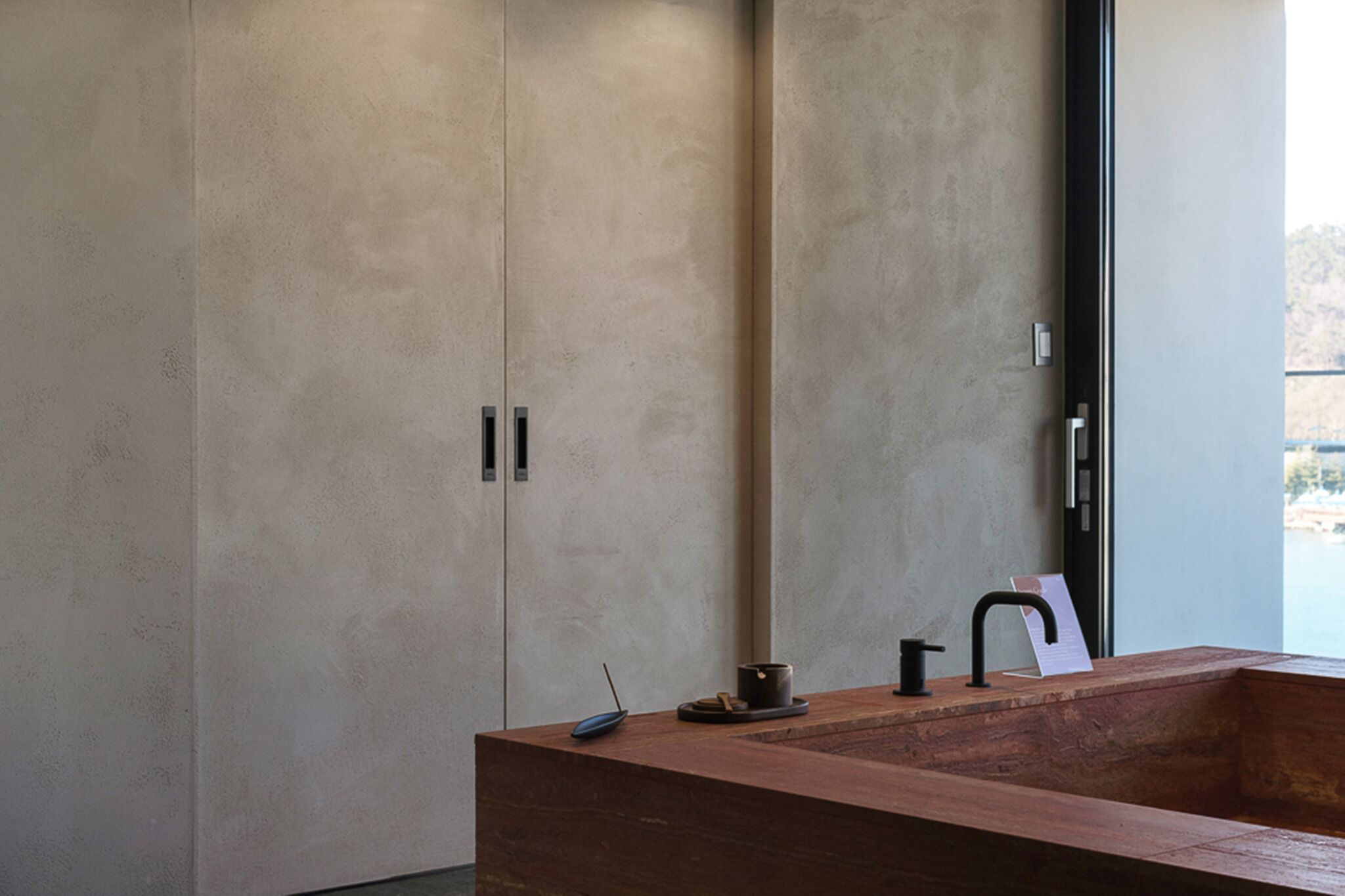 Un bagno moderno con un lavandino spazioso, uno specchio e vista sull'esterno.