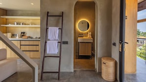 A modern kitchen with built-in shelves, a wooden ladder, and a round mirror above the sink. - Ubud Center Oasis by Betterplace (Ubud)