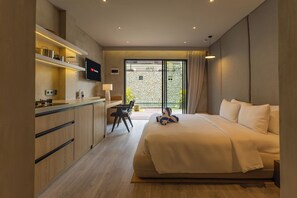 Una habitación de hotel moderna con cama, escritorio y televisor.