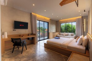 Una habitación de hotel moderna con cama, escritorio, televisor y balcón con vistas.