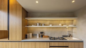 A modern kitchen with wooden cabinets, white countertops, and built-in shelves. - Ubud Center Oasis by Betterplace (Ubud)