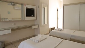 A hotel room with a bed, a bedside table, a mirror, a window, and a wall-mounted air conditioner. - HOTEL BİNLİK (Dalyan)