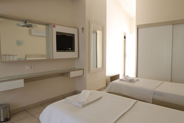 A hotel room with a bed, a bedside table, a mirror, a window, and a wall-mounted air conditioner. - HOTEL BİNLİK (Dalyan)