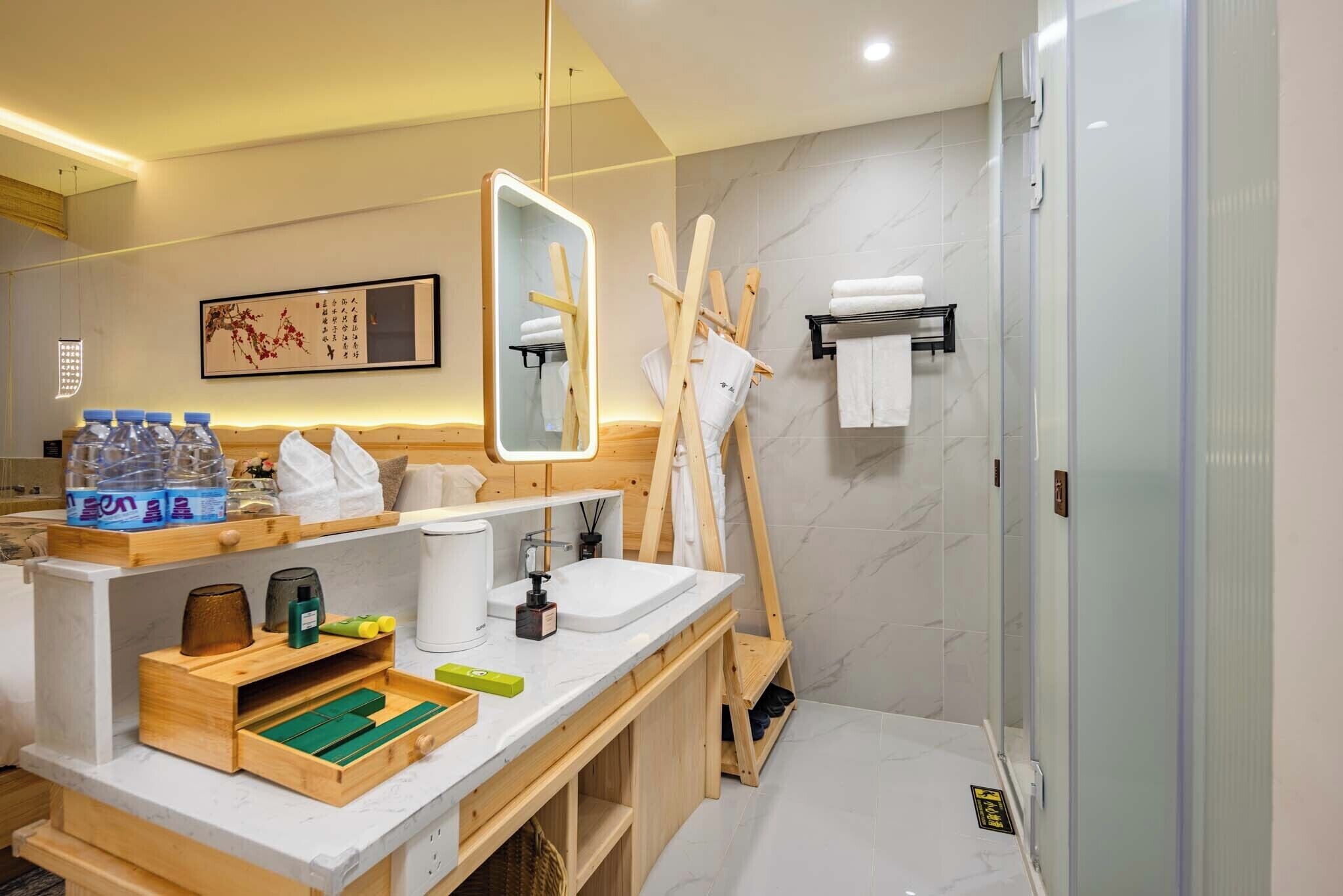 A modern bathroom with a wooden vanity, a large mirror, a shower, and a towel rack.