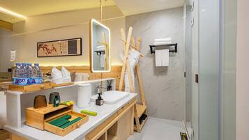 A modern bathroom with a wooden vanity, a large mirror, a shower, and a towel rack.