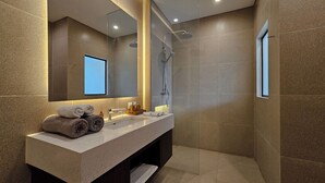 Un bagno moderno con uno specchio grande, una doccia e un mobile lavabo con asciugamani.