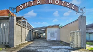 Ein verschlossenes Tor zum Duta Hotel, ein klarer Himmel darüber.