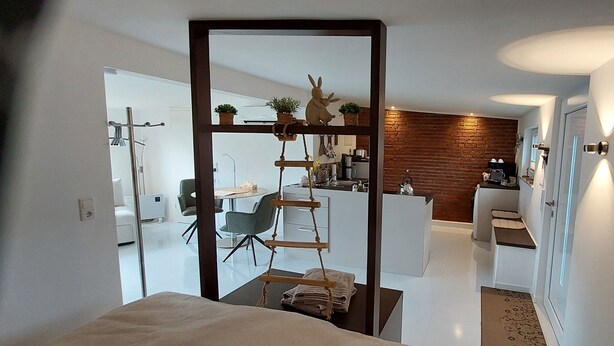 A modern interior with a kitchen, dining area, and a visible bathroom. - Extertal garden chalet with heated outdoor whirlpool Dogs free of charge (Extertal)