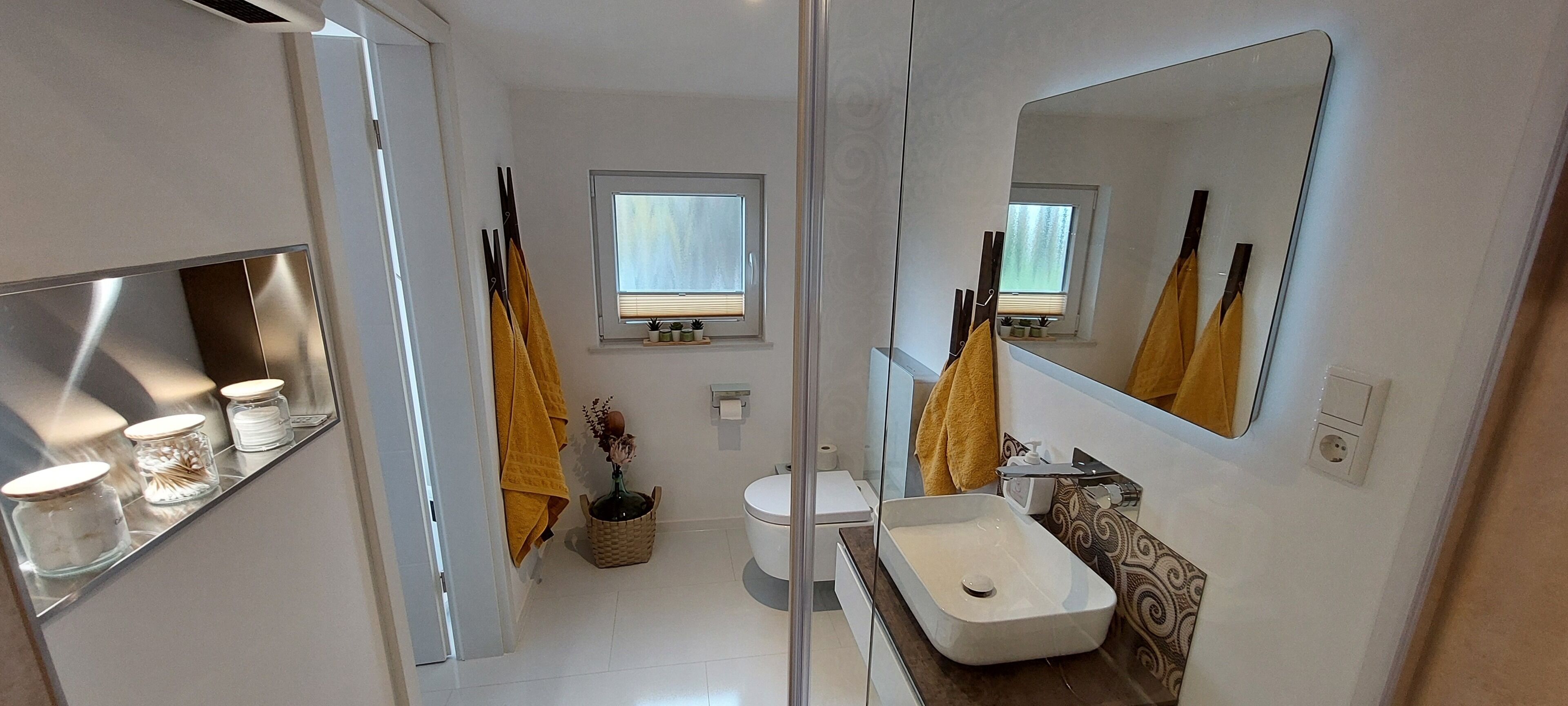 A bathroom with a white sink, mirror, and a window.