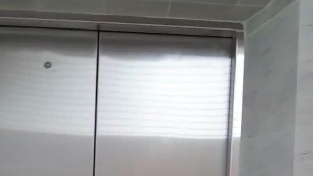 Een metalen liftdeur in een modern gebouw.