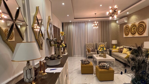 A modern living room with a sofa, armchairs, a coffee table, and decorative items.