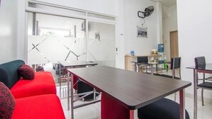 Une pièce moderne comprenant une table à manger, des chaises, un canapé et un ventilateur.