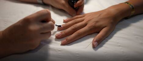 A close-up of hands with one hand painting the other.