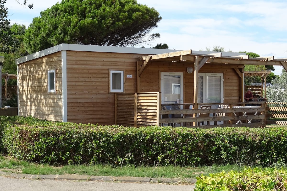 Eine Holzhütte mit Veranda, Tür und Fenster.
