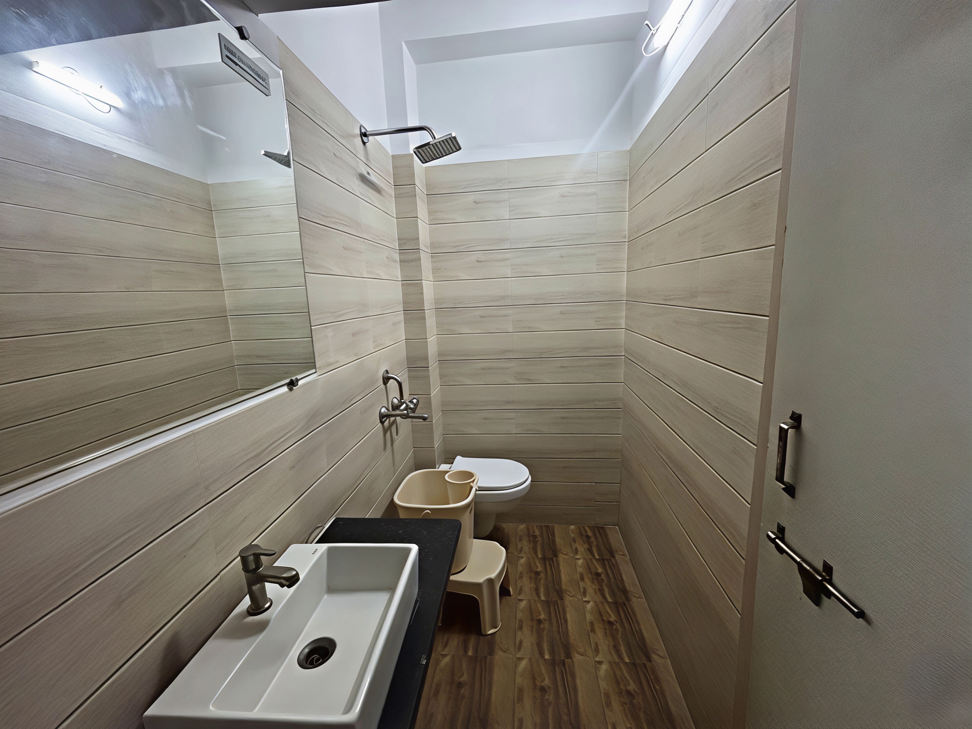 A compact bathroom with a sink, toilet, and shower.