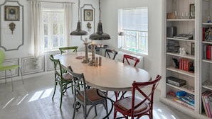 A dining area with a round table, chairs, a chandelier, and a bookshelf with books and decorative items. - 2 bedroom cozy home in Væggerløse (Væggerløse)