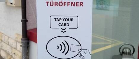 A self-check-in door opener with a card reader and instructions for use.