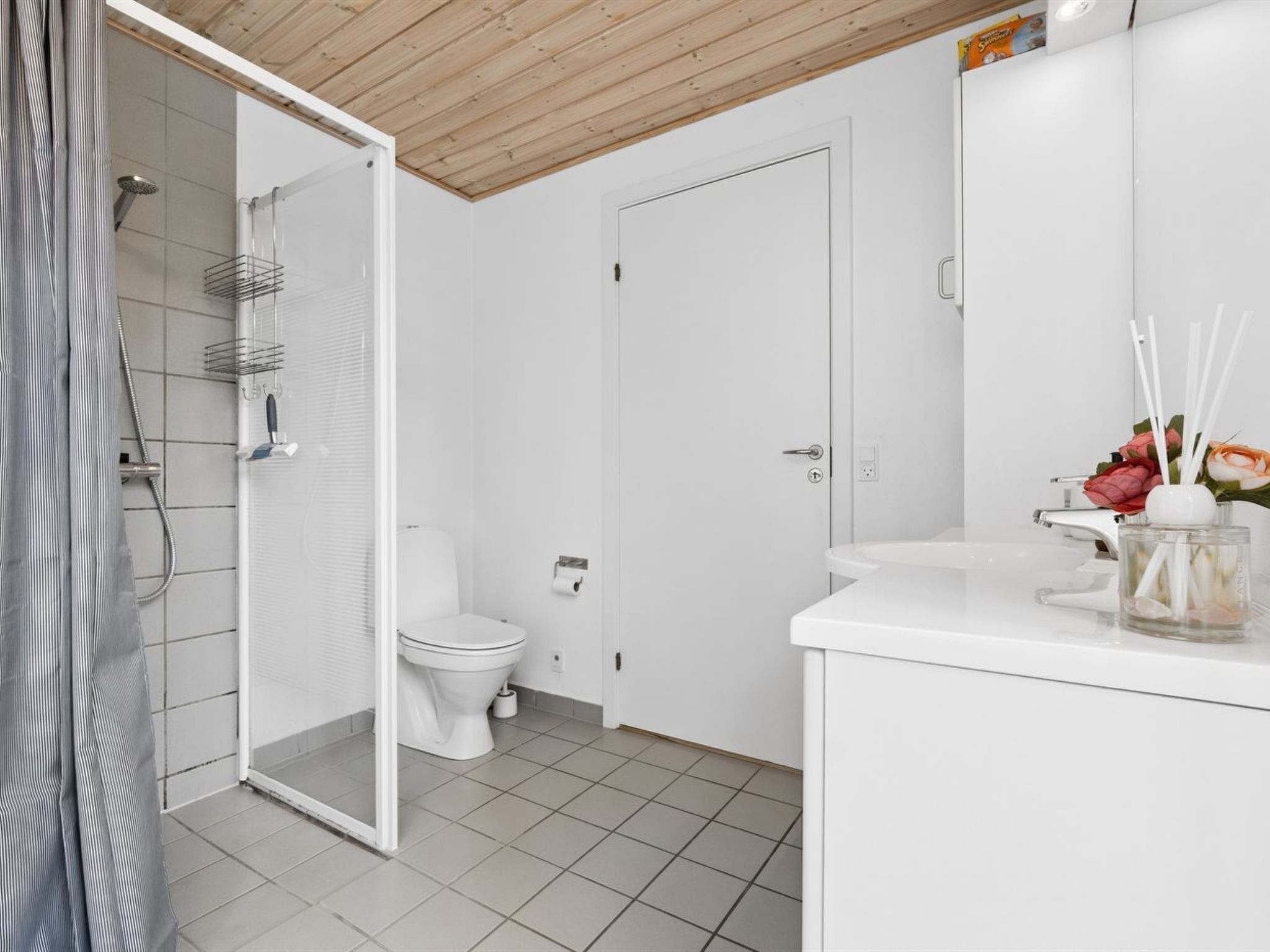 A modern bathroom with a shower, toilet, and sink.