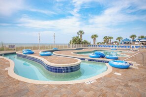 A pool area with blue water, lounge chairs, and a sign indicating shallow water no diving allowed. - Cozy 2-bedroom condo on the 10th Floor, located in fantastic North Myrtle Beach (North Myrtle Beach)