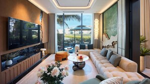 Una sala de estar moderna con un televisor de pantalla plana, un sofá, una mesa de centro y un ventanal con vistas al exterior.