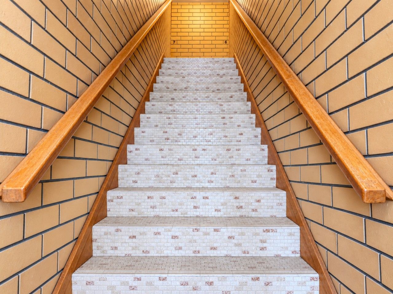A staircase with wooden handrails and patterned steps.