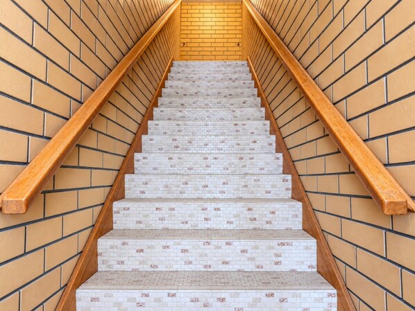 A staircase with wooden handrails and patterned steps.