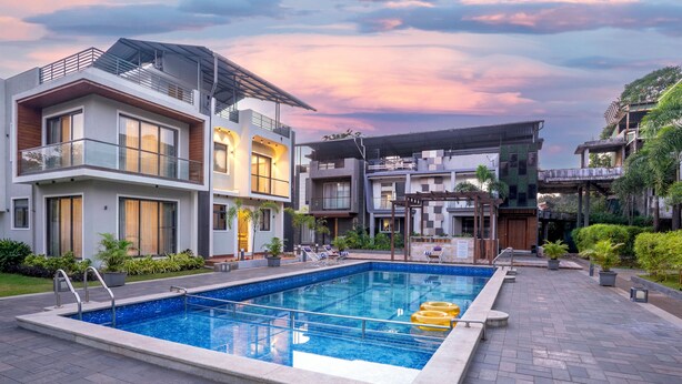 A modern residential complex with a swimming pool, multiple balconies, and a well-maintained garden. - Alaya Stays Rosalia 3BHK Villa with Pool (Lonavala)