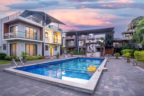 A modern residential complex with a swimming pool, multiple balconies, and a well-maintained garden. - Alaya Stays Rosalia 3BHK Villa with Pool (Lonavala)