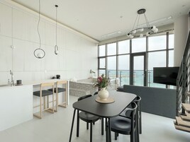Una cocina moderna con comedor, ventanas amplias y televisión.