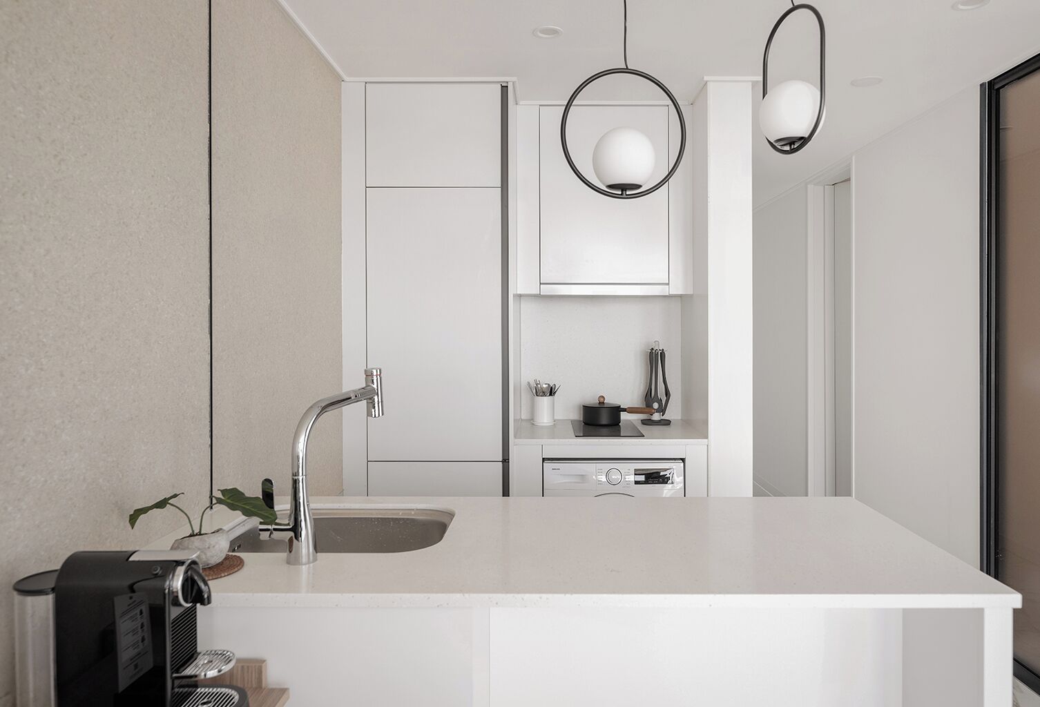 A modern kitchen with a central island, stainless steel appliances, and pendant lighting.