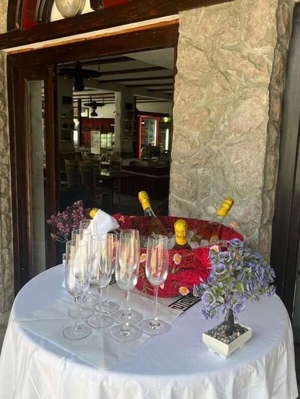 A table set with champagne flutes, a small potted plant, and a decorative item. - Hotel Neron i River View (Bihać)