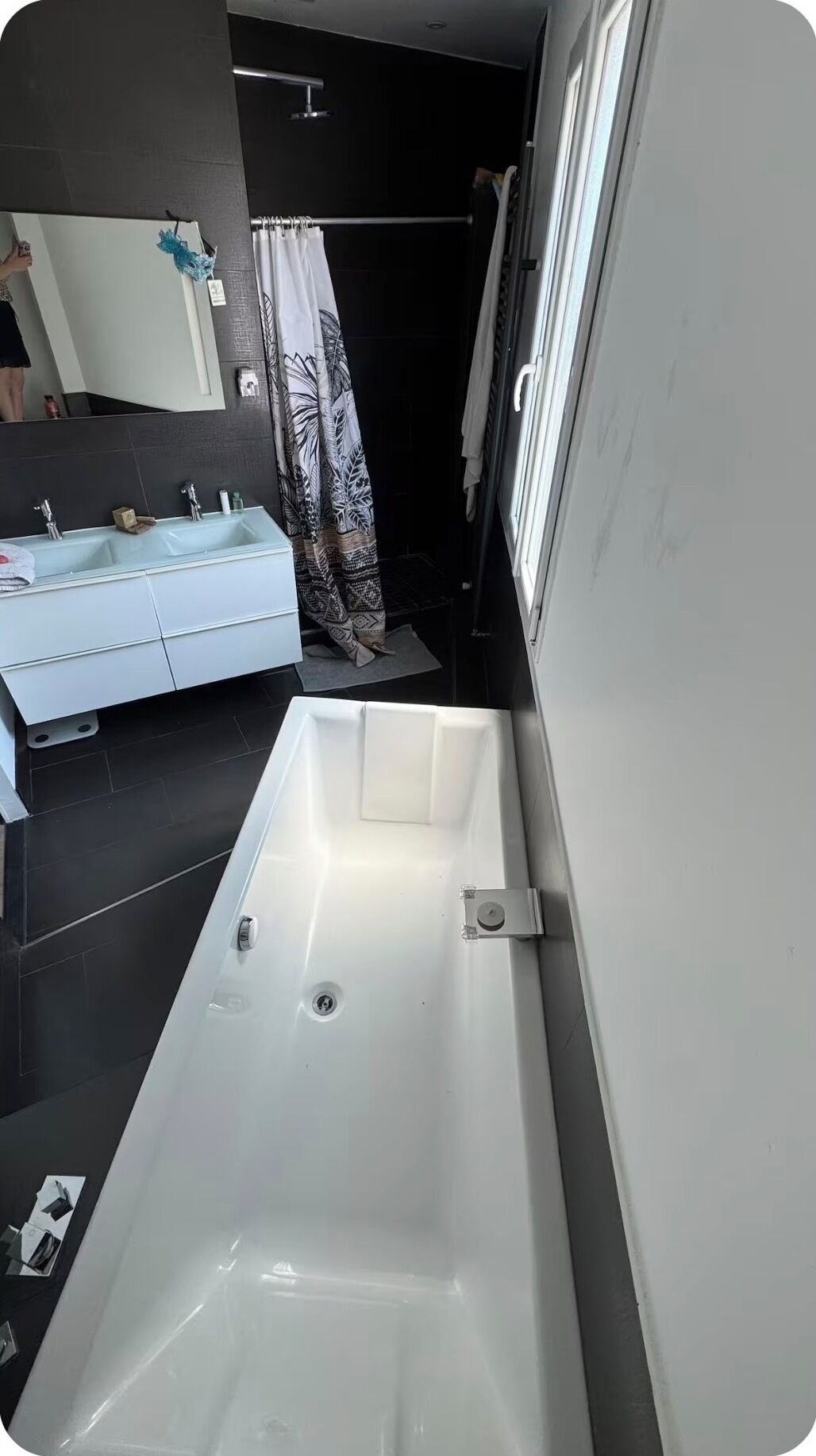 Une salle de bain moderne avec une grande baignoire, un lavabo blanc et un miroir.