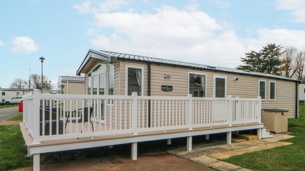 A mobile home with a white deck, a covered patio, and a small shed. - 49 Cader Idris, Hafan-y-mor Holiday Park (Pwllheli)