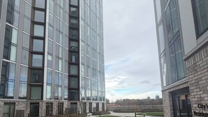 Um edifício moderno com grandes janelas e um pátio com mesas ao ar livre.