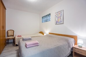 A bedroom with two single beds, a wooden wardrobe, a chair, and two wall-mounted artworks. - Rural Apt Arya: Garden & BBQ (Koper)