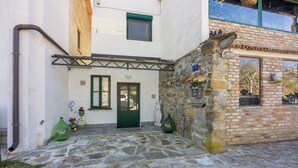 Un edificio de piedra con una puerta verde, un ventanal pequeño y un letrero con el número 20.