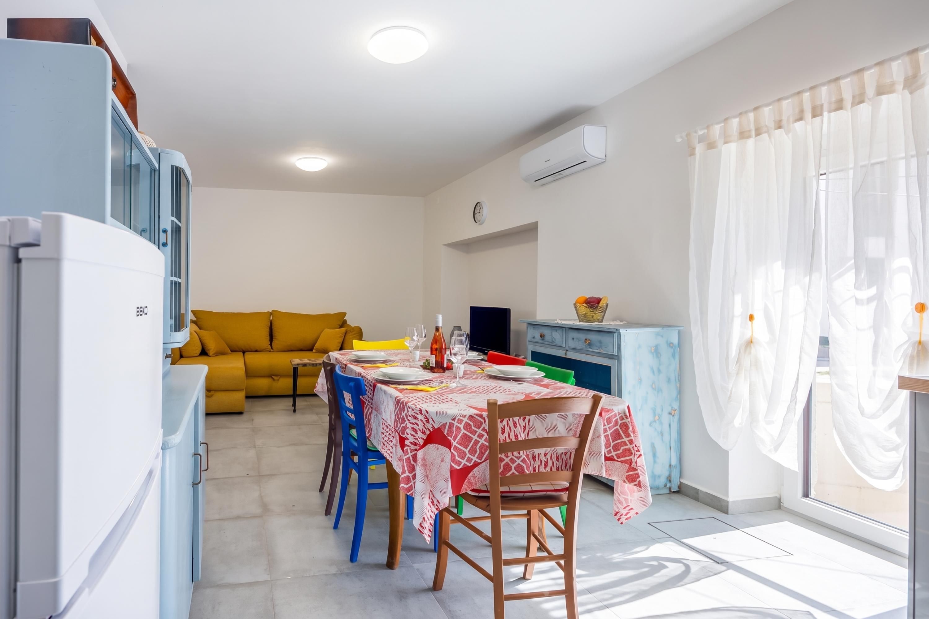 Un espacio habitable compacto con comedor, kitchenette y sofá.