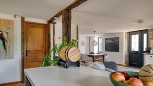 Eine Küche mit Marmorarbeitsplatte, einem Holzfass und einer Fruchtschale.
