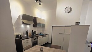 Eine kleine Küche mit Essbereich, inklusive Tisch, Stühlen und Kühlschrank.