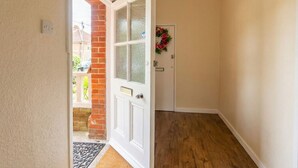 A hallway with a white door, a brick wall, and a wooden floor. - New Forest getaway just two minutes from the station (Hampshire)